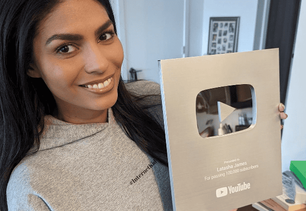 Latasha James – YouTube Creator Accelerator Woman smiling holding YouTube Silver Play Button award for 100,000 subscribers.